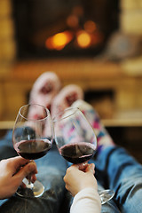 Image showing Young romantic couple sitting and relaxing in front of fireplace