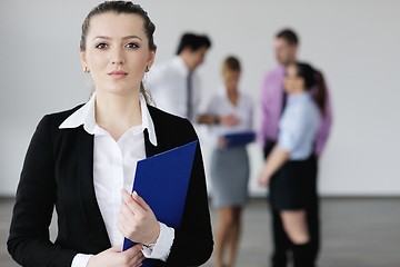 Image showing business woman standing with her staff in background