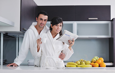 Image showing Happy couple reading the newspaper in the kitchen at breakfast