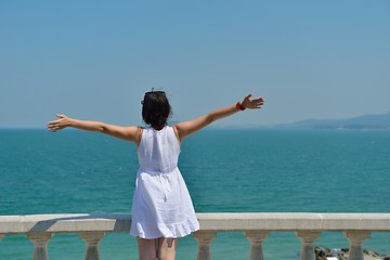 Image showing young woman with spreading arms to sky