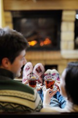 Image showing Young romantic couple relax on sofa in front of fireplace at hom