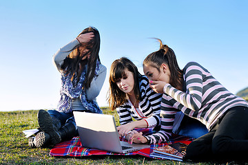 Image showing group of teens working on laptop outdoor