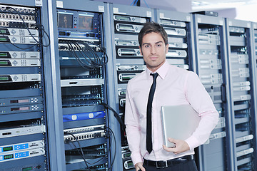 Image showing businessman with laptop in network server room