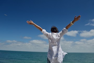 Image showing young woman with spreading arms to sky