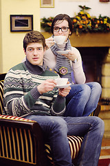 Image showing Young romantic couple sitting and relaxing in front of fireplace