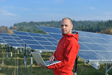 Image showing engineer using laptop at solar panels plant field