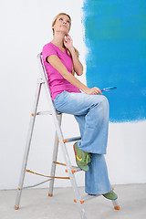 Image showing happy smiling woman painting interior of house