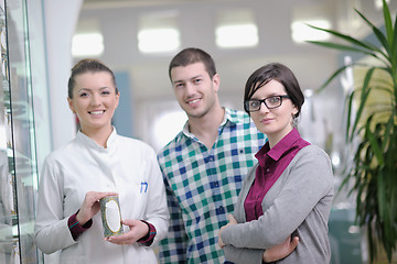 Image showing pharmacist suggesting medical drug to buyer in pharmacy drugstor