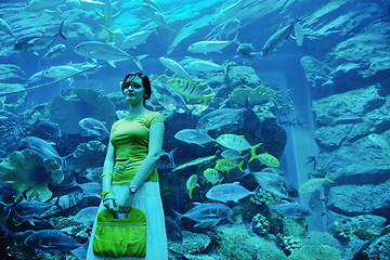 Image showing young woman with big aquarium in backgrond