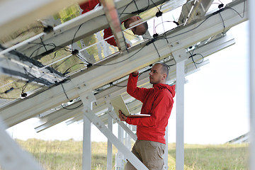 Image showing engineer using laptop at solar panels plant field