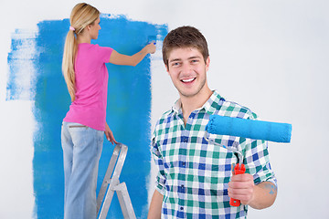 Image showing happy couple paint wall at new home