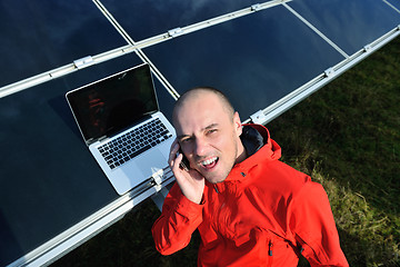 Image showing engineer using laptop at solar panels plant field