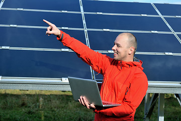 Image showing engineer using laptop at solar panels plant field