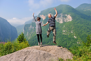 Image showing happy young couple jumping in the air