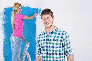 Image showing happy couple paint wall at new home