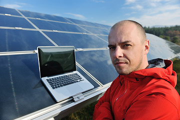 Image showing engineer using laptop at solar panels plant field