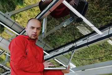 Image showing engineer using laptop at solar panels plant field