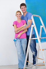 Image showing happy couple paint wall at new home