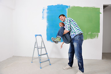 Image showing happy couple paint wall at new home