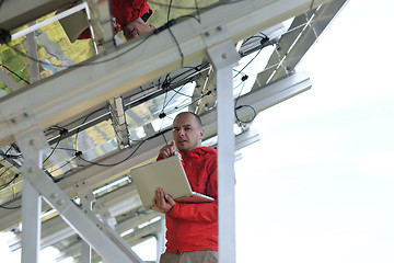 Image showing engineer using laptop at solar panels plant field