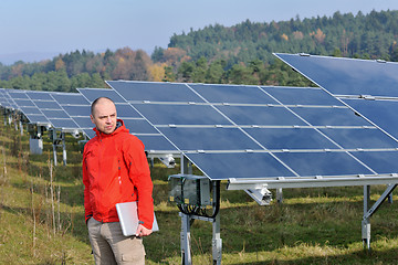 Image showing engineer using laptop at solar panels plant field