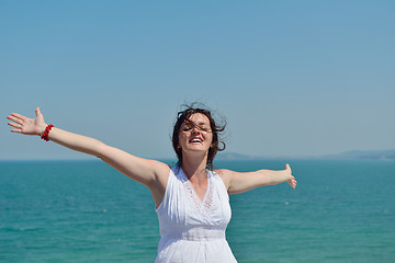 Image showing happy young woman with spreading arms to sky