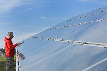 Image showing engineer using laptop at solar panels plant field