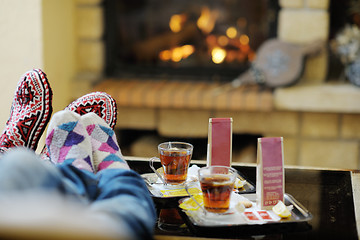 Image showing Young romantic couple sitting and relaxing in front of fireplace