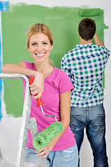 Image showing happy couple paint wall at new home