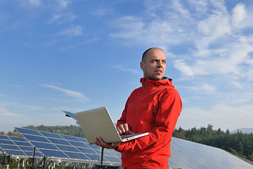 Image showing engineer using laptop at solar panels plant field