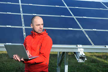 Image showing engineer using laptop at solar panels plant field