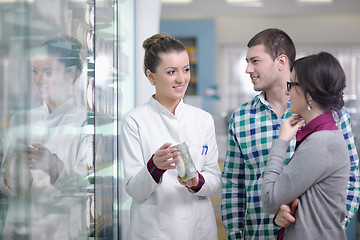 Image showing pharmacist suggesting medical drug to buyer in pharmacy drugstor