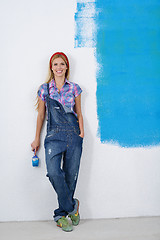 Image showing happy smiling woman painting interior of house