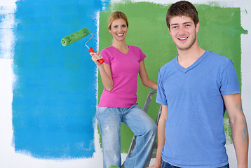 Image showing happy couple paint wall at new home