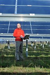 Image showing engineer using laptop at solar panels plant field