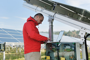 Image showing engineer using laptop at solar panels plant field