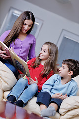 Image showing young mom play with their kids at home and reading book