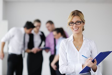 Image showing business woman standing with her staff in background