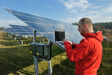 Image showing engineer using laptop at solar panels plant field