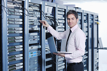 Image showing businessman with laptop in network server room