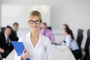 Image showing business woman standing with her staff in background