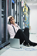 Image showing businessman with laptop in network server room