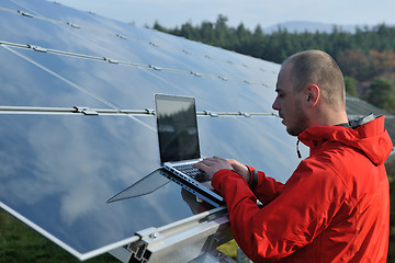 Image showing engineer using laptop at solar panels plant field