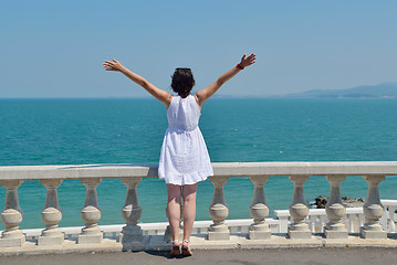 Image showing happy young woman with spreading arms to sky