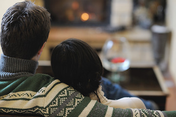 Image showing Young romantic couple sitting and relaxing in front of fireplace