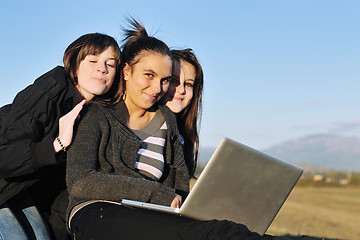 Image showing group of teens working on laptop outdoor