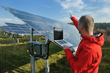 Image showing engineer using laptop at solar panels plant field