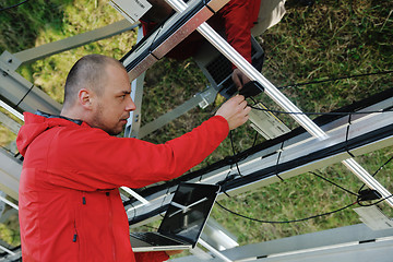 Image showing engineer using laptop at solar panels plant field