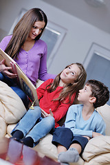 Image showing young mom play with their kids at home and reading book