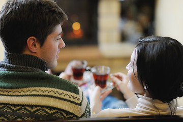 Image showing Young romantic couple sitting and relaxing in front of fireplace